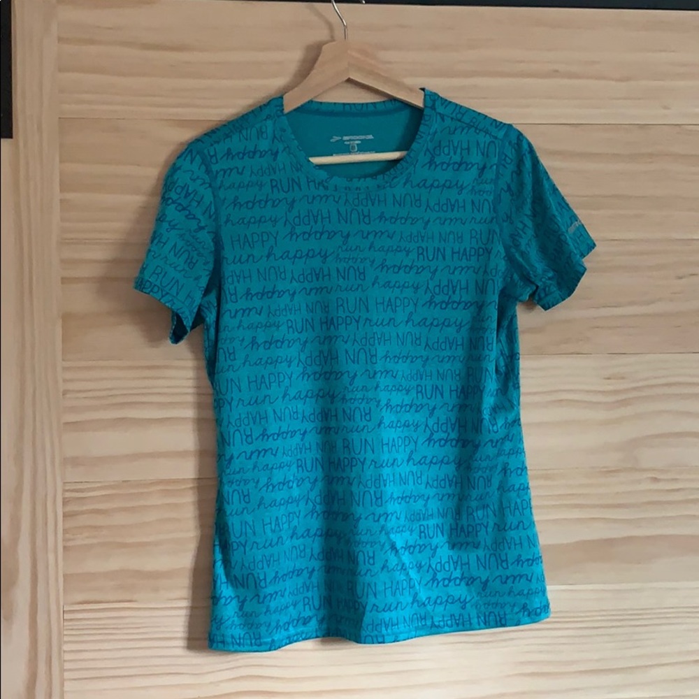 Blue “Run Happy” Brooks technical running shirt.